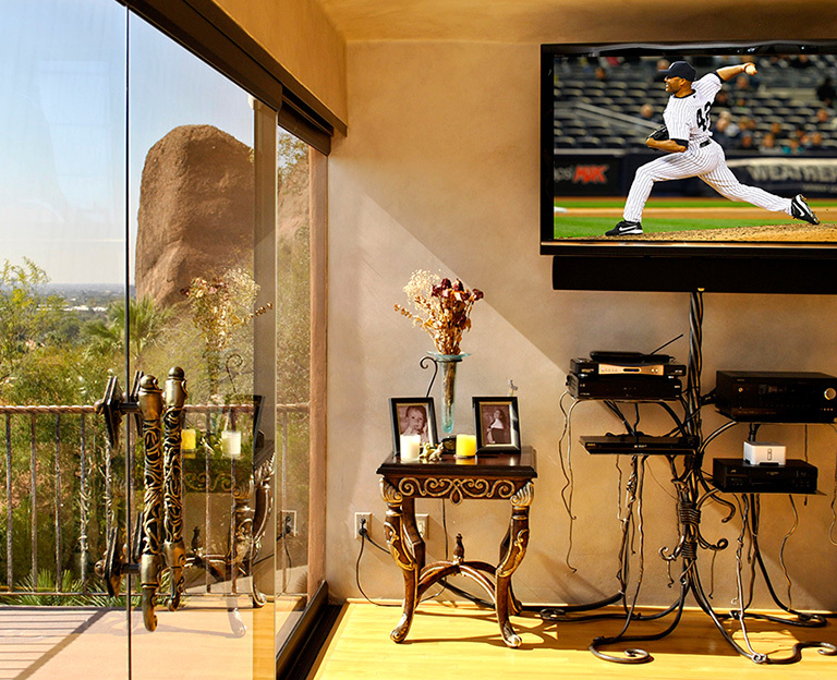Wall-mounted TV with audio video equipment and desert mountain view