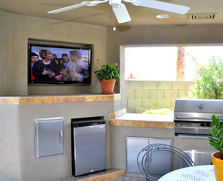 Outdoor kitchen with weatherproof TV installation